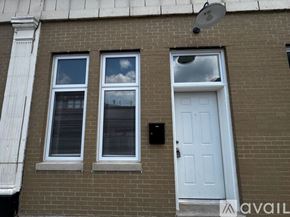 Chicago apartment for rent - A white door is on the right side of a brick building.