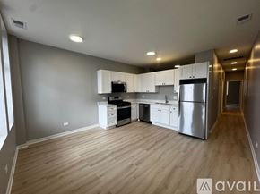 Chicago apartment for rent - A kitchen with wooden floors and stainless steel appliances.