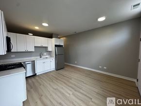 Chicago apartment for rent - A kitchen with white cabinets and a wooden floor.
