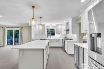 Savannah house for rent - A modern kitchen with white cabinets and a large island.
