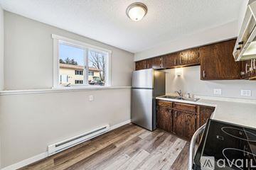 River Falls apartment for rent - A kitchen with a refrigerator, sink, and cabinets.