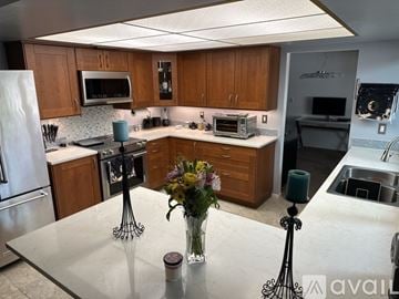 Glendale house for rent - A kitchen with a table in the middle and a vase of flowers on it.