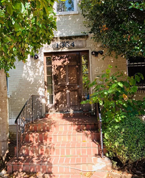 Washington apartment for rent - A set of stairs leads up to a door under a tree.