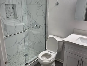 Los Angeles apartment for rent - A white toilet in a bathroom with a marble shower.