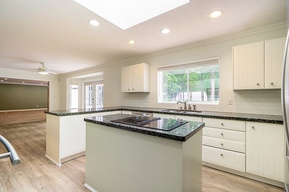 Langley apartment for rent - A kitchen with a black granite countertop and white cabinets.