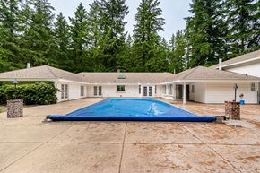 Langley apartment for rent - A house with a blue tarp covering a pool in the backyard.