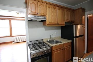 Chicago apartment for rent - A kitchen with wooden cabinets and a stainless steel refrigerator.