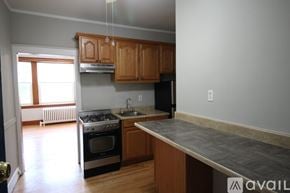 Chicago apartment for rent - A kitchen with wooden cabinets and a black refrigerator.
