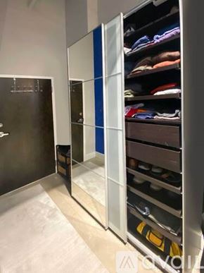 Richmond apartment for rent - A walk-in closet with a mirror and shelves filled with clothes.
