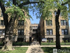 Chicago apartment for rent - A tree-lined walkway leads to a brick building with a "For Rent" sign.