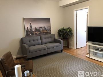 Chicago apartment for rent - A grey sofa sits in a living room with a cityscape picture behind it.