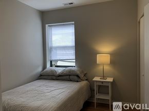 Chicago apartment for rent - A bedroom with a bed, nightstand, and window.