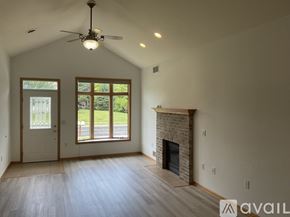 Mc Farland apartment for rent - A spacious room with a fireplace and a ceiling fan.
