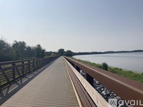 Mc Farland apartment for rent - A wooden walkway leads to a body of water with trees in the background.