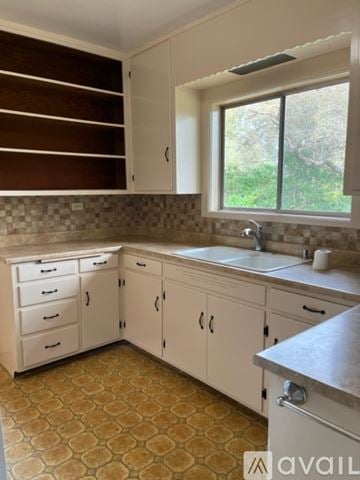 Sebastopol house for rent - A kitchen with white cabinets and a tiled floor.