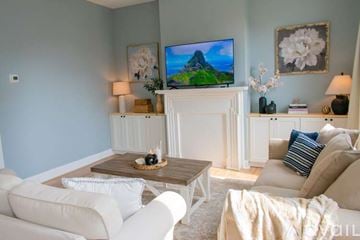 Lafayette apartment for rent - A living room with a white couch and wooden floors.