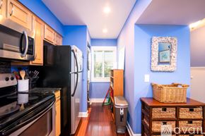 Folly Beach condo for rent - A kitchen with a black refrigerator and stove top oven.