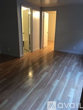 Seattle apartment for rent - A room with wooden floors and a window with blinds.