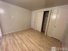 Seattle apartment for rent - A room with light wood flooring and white walls, with a door open to another room.