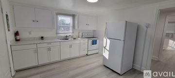 Spring Lake house for rent - A kitchen with white cabinets and a white fridge.