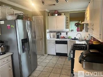 Jonesboro house for rent - A kitchen with a refrigerator, oven, and sink.