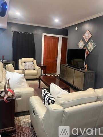 Indianapolis townhouse for rent - A living room with a white sofa and a wooden cabinet.