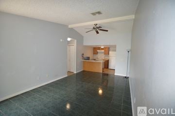 Spring Hill apartment for rent - A room with a ceiling fan and a kitchenette in the background.