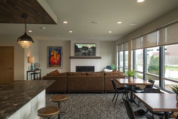 Greenfield apartment for rent - A modern living room with a fireplace and a painting of a sunset.
