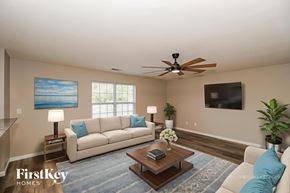 Midland house for rent - A living room with a beige couch, a coffee table, and a ceiling fan.