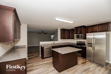 Midland house for rent - A kitchen with brown cabinets and a FirstKey Homes logo.