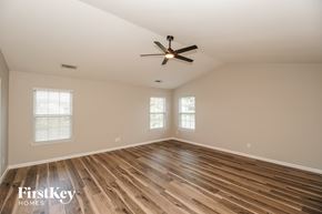 Midland house for rent - A spacious room with wooden flooring and a ceiling fan.
