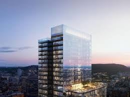 Montreal apartment for rent - A modern glass skyscraper stands tall against a twilight sky.