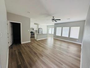 Bay City house for rent - A spacious room with wood flooring and a ceiling fan.