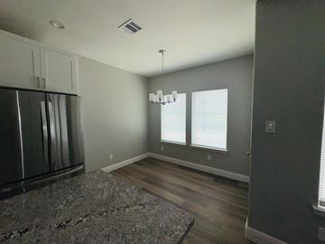 Bay City house for rent - A kitchen with a granite counter top and a refrigerator.