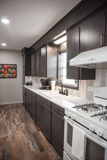 Houma apartment for rent - A kitchen with a white stove top oven and dark wood cabinets.