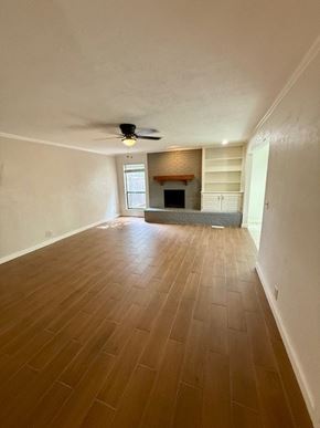 Oklahoma City apartment for rent - A room with a fireplace and a ceiling fan.