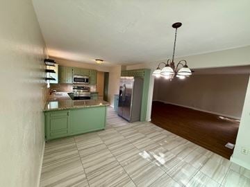 Oklahoma City apartment for rent - A kitchen with green cabinets and a refrigerator.