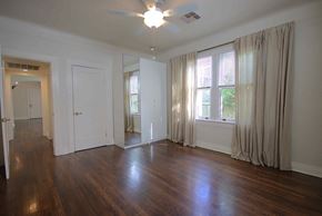 New Orleans house for rent - A room with wooden floors and a ceiling fan.