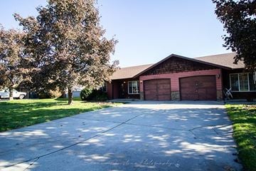 Hayden house for rent - A house with a red garage door is surrounded by trees.