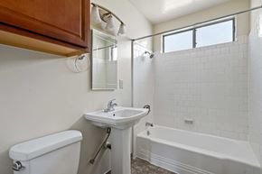Burbank apartment for rent - A white sink is on a white pedestal in a white tiled bathroom.
