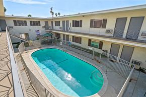 Burbank apartment for rent - A swimming pool in a courtyard surrounded by a metal fence.