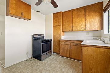 Burbank apartment for rent - A kitchen with wooden cabinets and a black stove top oven.