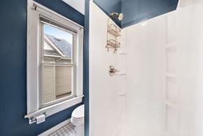 Columbus house for rent - A bathroom with a toilet, a window, and a shower.