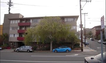Oakland apartment for rent - A blue car is parked on the side of the street.