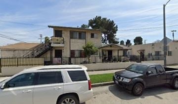 Los Angeles apartment for rent - A white SUV is parked in front of a house with a black pickup truck parked in front of a house.