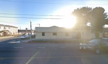 Los Angeles apartment for rent - A sunny day in a parking lot with a white building and a tree.