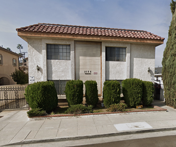 San Gabriel apartment for rent - A house with a red tile roof and white walls with a brown door and windows.