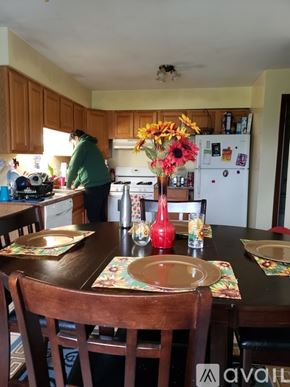 Burnham apartment for rent - A woman is standing in a kitchen with a table set for a meal.