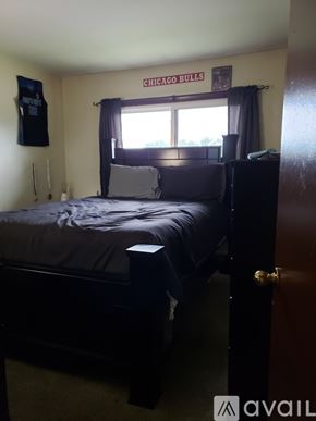 Burnham apartment for rent - A bedroom with a bed, dresser, and a Chicago Bulls banner on the wall.