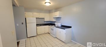Lawrence house for rent - A kitchen with white appliances and cabinets.